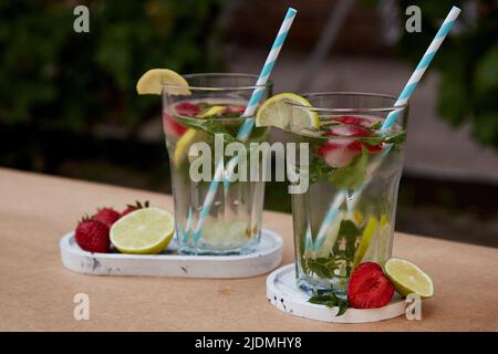 Natural homemade summer cocktails with strawberry ice, lime, lemons and mint. Infused, vitaminized, detox healthy drinks. Refreshing, diet, natural water Stock Photo