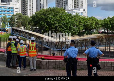 Hong Kong, China. 22nd June, 2022. Two police officers block access to the construction site where workers are working to repair a bridge broken in two in Hong Kong following a fire on high voltage electric cables A burned bridge and deprived 140,000 households of electricity in Hong Kong (Photo by Emmanuel Serna/ SOPA Images/Sipa USA) Credit: Sipa USA/Alamy Live News Stock Photo