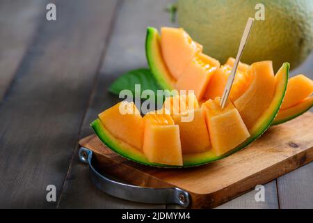 slice of japanese melons, orange melon or cantaloupe melon on wood background, summer fruits Stock Photo