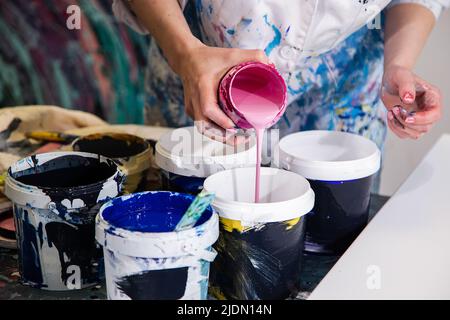 Close-up of woman applying white paint … – License image