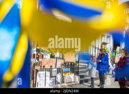 Blue and yellow ribbons are blown by the wind as messages against Russia's invasion of Ukraine are left near the Russian Embassy in London. Stock Photo