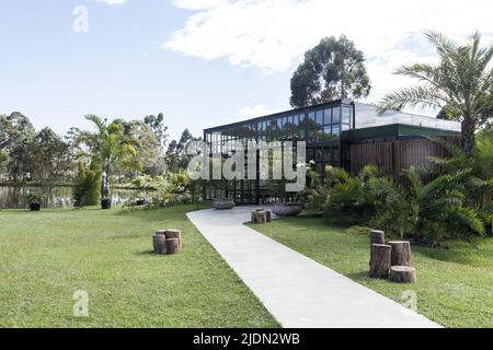 Pavilion in an urban garden for recreation, wooden lounge outdoors, peaceful gazebo set in a mature garden, blue sky sunny and cloudy. Stock Photo