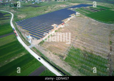 Aerial view of electrical power plant under construction with truck delivering assembly parts for solar panels on metal frame for producing electric Stock Photo