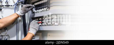 Electrical engineers check electrical control devices with a multimeter. Stock Photo