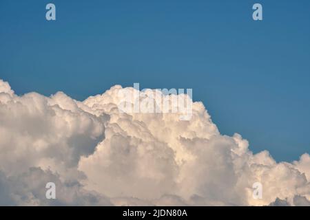 White puffy cumulus clouds on summer blue sky Stock Photo