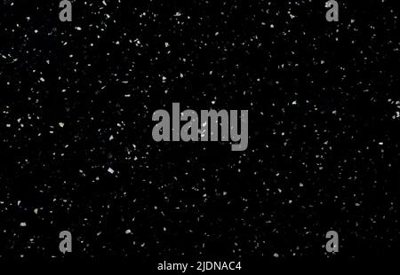 Background and texture of black stone with white crumbs. Modern minimalist background, copy space Stock Photo