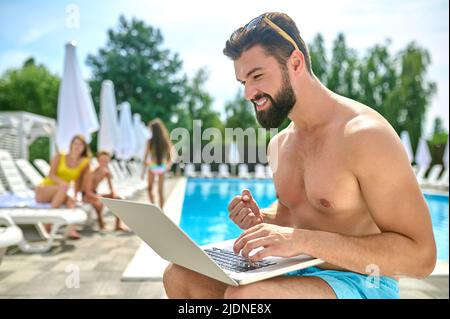 Male vacationer with his computer at the resort Stock Photo