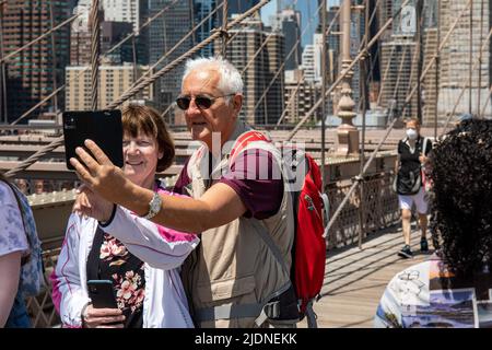 Elderly couple taking selfie on Brooklyn Bridge Pedestrian Walkway in New York City, United States of America Stock Photo