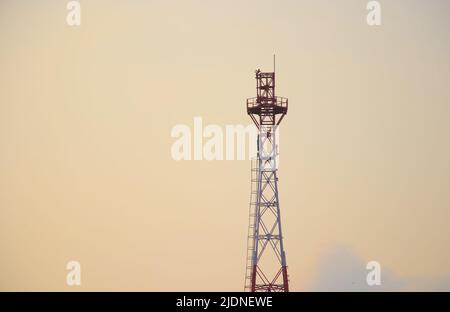 Railway communication tower in evening sky Stock Photo