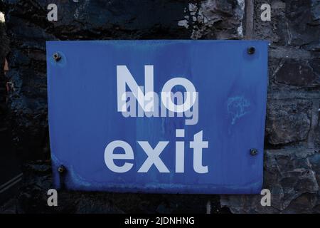 No Exit sign in white lettering on blue background fixed to a brick wall Stock Photo