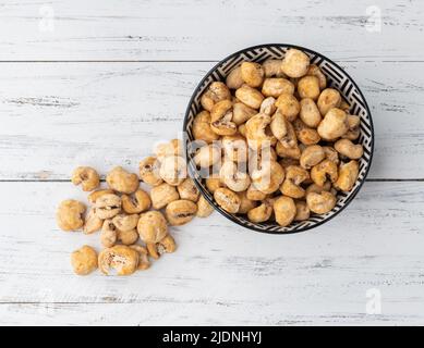 Canjica, hominy or white corn popcorn, sweet popcorn in a bowl over wooden table. Stock Photo