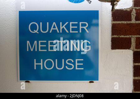 Quaker Meeting House sign written in white letters on a blue background fixed to a white cement wall Stock Photo