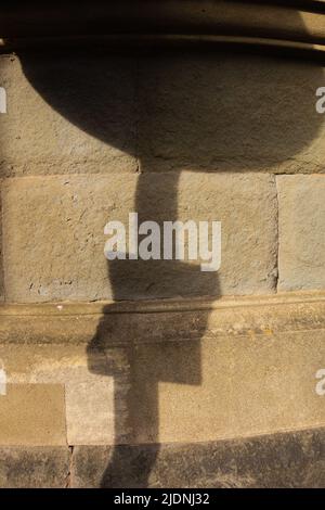 road sign shadow on a grey and yellow stone wall Stock Photo