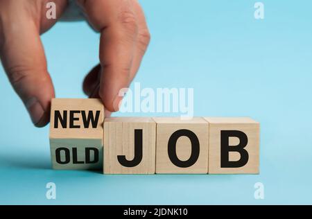 Old Job and New Job, Career change conceptual image. Hand is turning wooden cubes and changes the expression old job to new job. Stock Photo