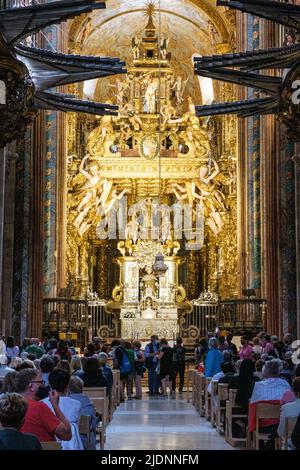 Spain, Santiago de Compostela, Galicia. People athering for Mass, Cathedral of Santiago de Compostela. Main Altar in background. Stock Photo