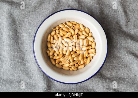 Roasted peeled peanuts in a bowl. Top view. Stock Photo