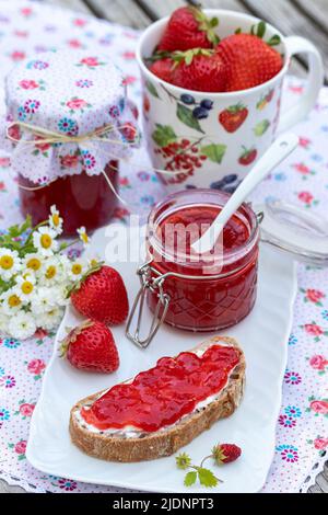 strawberry jam on piece of bread and in glass Stock Photo
