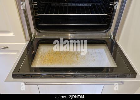 Dirty oven with grease on the glass built into the furniture in the home kitchen Stock Photo