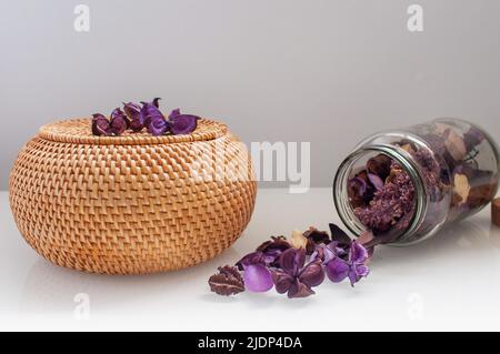 wicker rattan box craft round top with dried flowers and lavender on a white background Stock Photo