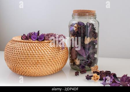 wicker straw box craft round on top with dried flowers and lavender on a white background Stock Photo