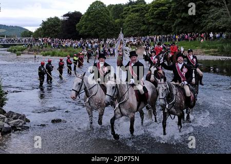 Peebles, UK. , . Beltane Wednesday - Cornets Installation, Rideout & Reel Peebles Cornet Iain Mitchell carries the flag on the traditional riding of the Marches. Flanked by his left and right hand men, fording the river Tweed. ( Credit: Rob Gray/Alamy Live News Stock Photo