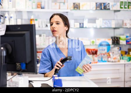 Confident woman pharmacist working at cash desk Stock Photo