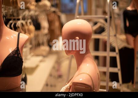 Mannequin of girl is viewed from side. Head without hair. Figure of man made of plastic. Details of clothing store. Stock Photo