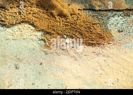 Wet sand on asphalt. Sand lies on ground. Details of road. Stock Photo