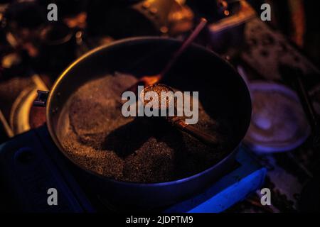 Coffee on sand. Coffee maker at festival. Preparation of strong drink. Details of oriental cuisine. Stock Photo