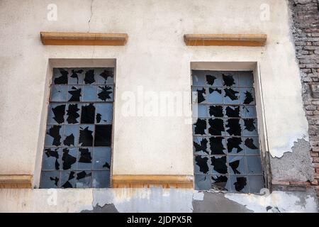 Picture of an old window with broken glass taken on an old industrial building left for decay. Stock Photo