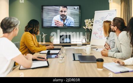 Group of innovative businesspeople having a video conference in a boardroom. Team of creative business professionals collaborating on a renewable ener Stock Photo