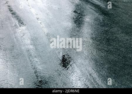 rough texture of wet dark pavement after rain. wet asphalt road background. Stock Photo