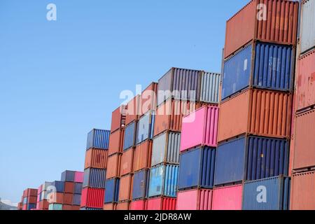 a pile of container in freight yard against a blue sky, transport background Stock Photo