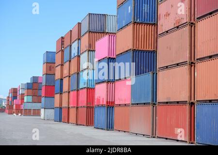 a pile of container in freight yard against a blue sky, transport background Stock Photo