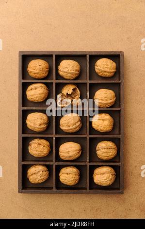 box with compartments filled with walnuts, one broken Stock Photo