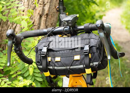 The flag of Ukraine is tied to the handlebars of a sports bike on the street of Ukraine, a bicycle bag on the handlebars, urban transport, cycling in Stock Photo
