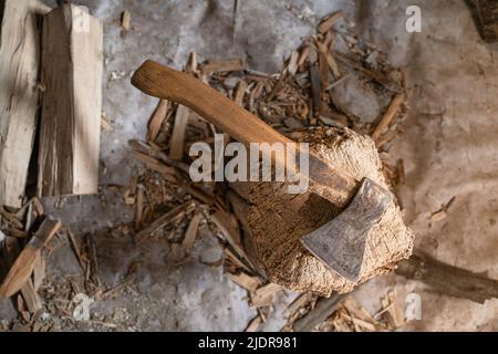 The ax lies on a deck for chopping firewood close-up against the background of chips and firewood, top view Stock Photo