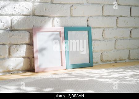 Photo frames on floor over white brick wall Stock Photo