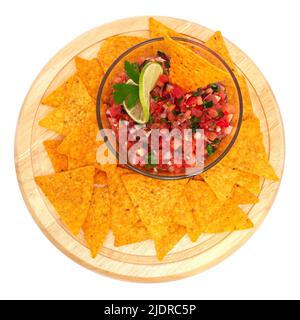 Glass bowl of tomato salsa dip with Tortilla chips isolated on white background Stock Photo