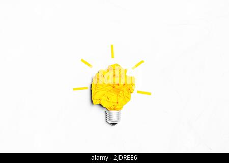 Glowing lightbulb flat-lay made from a screw base and yellow paper. Creative do it yourself concept. Stock Photo