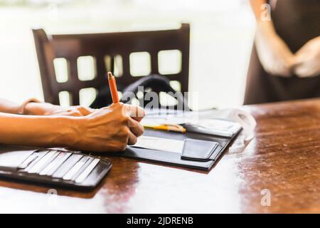 Woman signing slip payment credit card in restaurant. Stock Photo