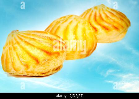 Three pink delicious appetizing profiterole eclair cakes on a sky background Stock Photo