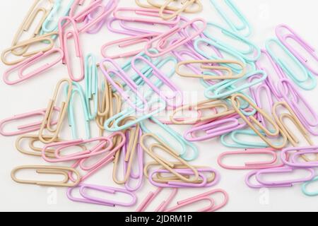 Multicolored paper clips scattered as textured background in full screen. Stationery concept. Stock Photo