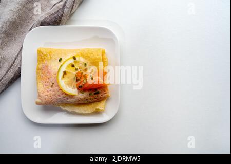 Cuisine of Normandy, galette pancake filled with goat cheese and smoked salmon served with fresh lemon, France Stock Photo