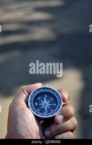 Hand holding the navigation compass blur background vertical Stock Photo