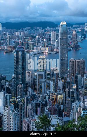 The expansive view at dusk of Victoria Harbour in Hong Kong, as seen from Victoria Peak, with the skyscrapers of Central in the foreground. Stock Photo