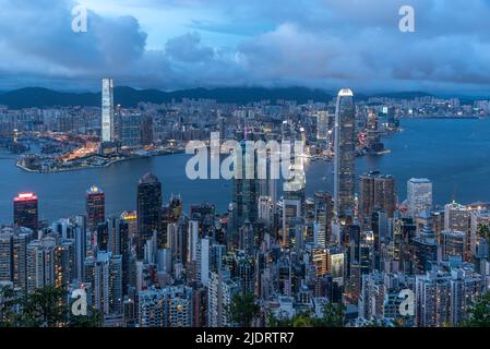 The expansive view at dusk of Victoria Harbour in Hong Kong, as seen from Victoria Peak, with the skyscrapers of Central in the foreground. Stock Photo