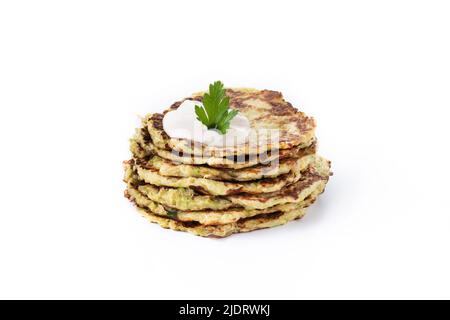 Zucchini fritters with yogurt sauce isolated on white background. Vegetable pancakes. Stock Photo
