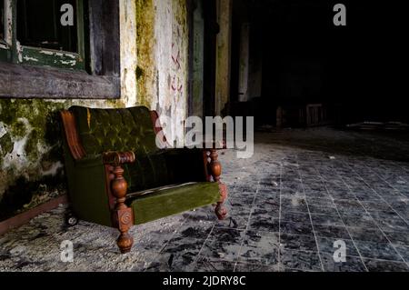 A green sofa in an abandoned building Stock Photo