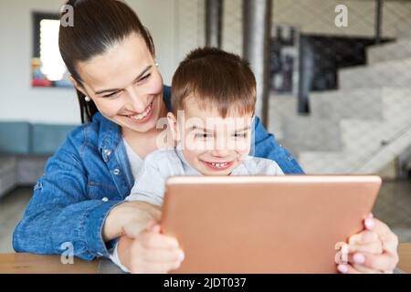 Mother and son video chatting together on computer with relatives or grandparents Stock Photo